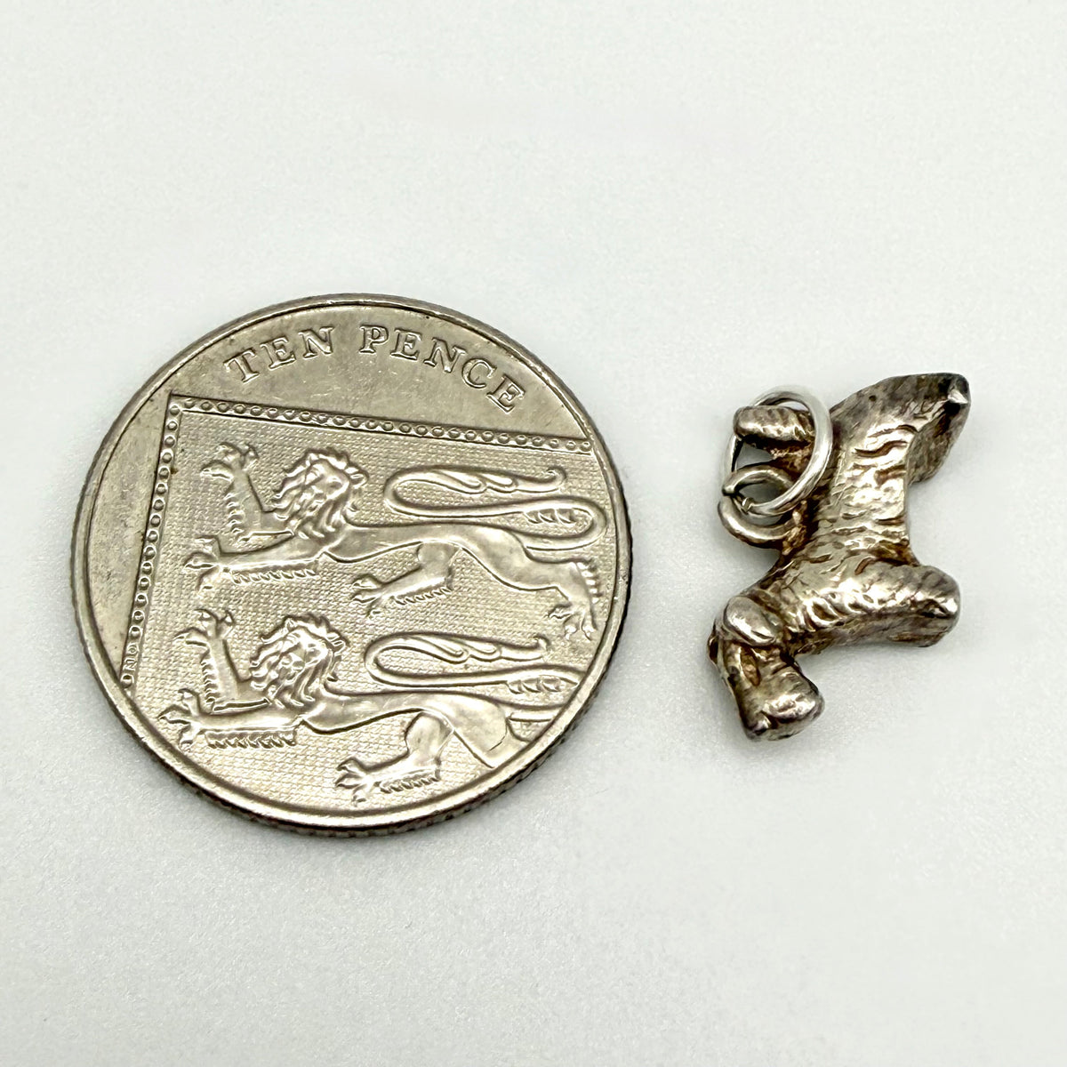 Side view of sterling silver terrier dog charm with textured fur and upright tail