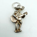A silver Mexican musician charm pendant featuring a detailed figure playing a guitar and holding a sombrero, shown on a plain light background.