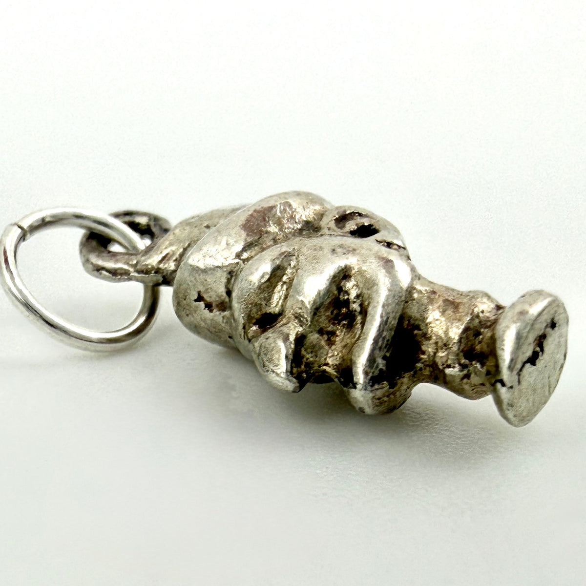 Side view of the Mr Punch charm showing its sculpted shape