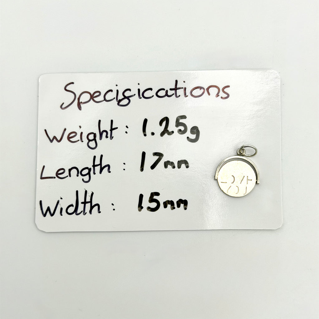 Sterling silver spinning fob charm beside its handwritten size and weight details
