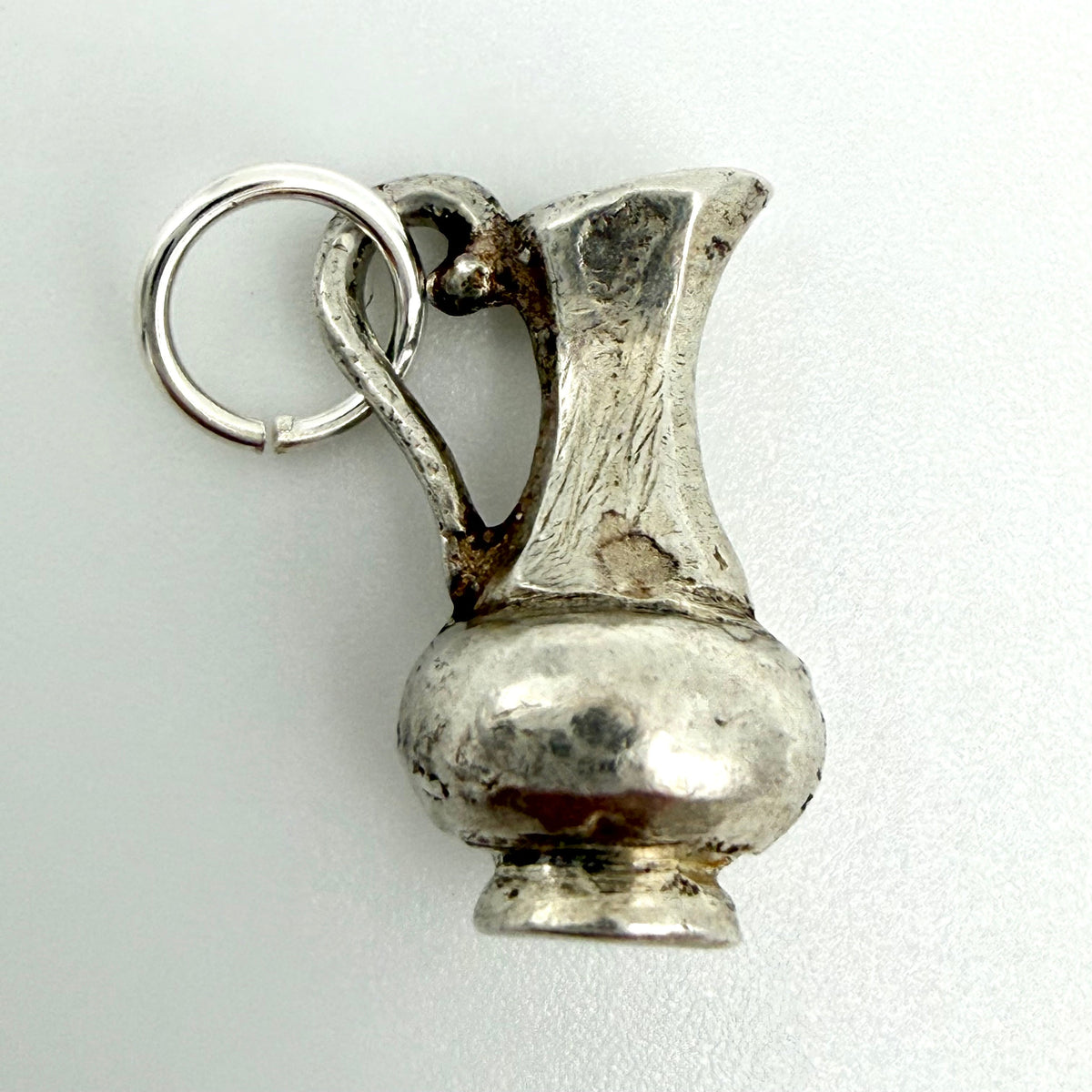 Side view of vintage sterling silver Aquarius water jug charm