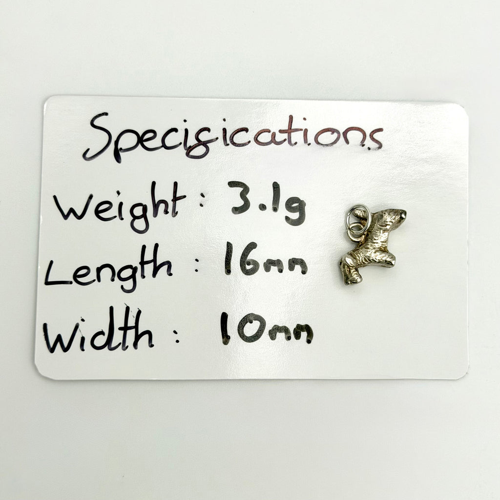 Opposite side of vintage silver terrier charm showing muzzle, tail and attachment ring