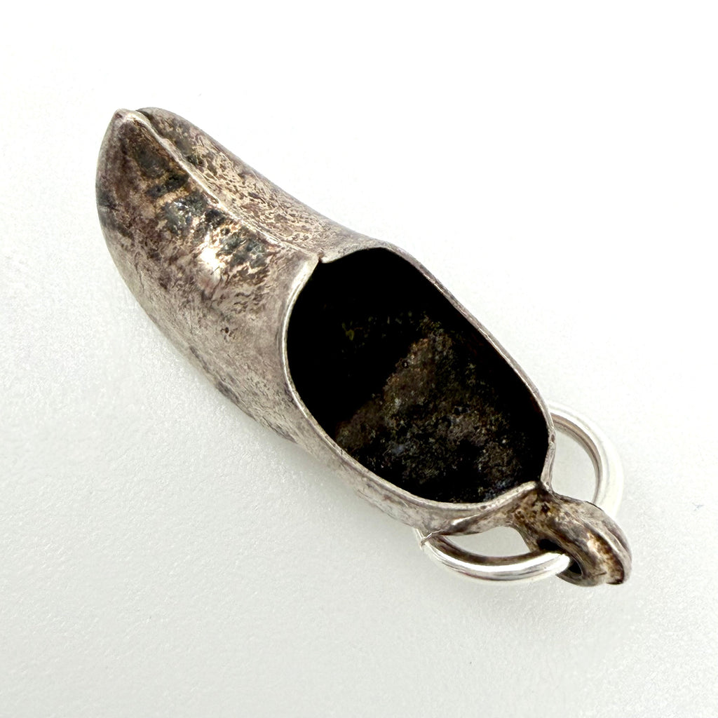 Dutch clog silver charm beside a ten pence coin for scale