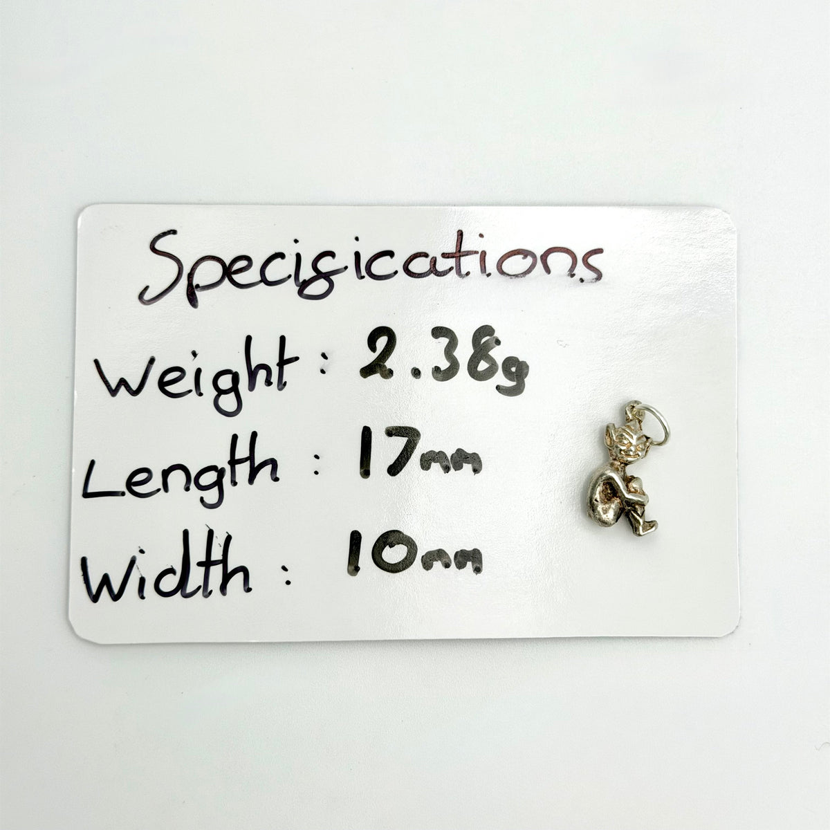 Front view of seated sterling silver imp pixie charm