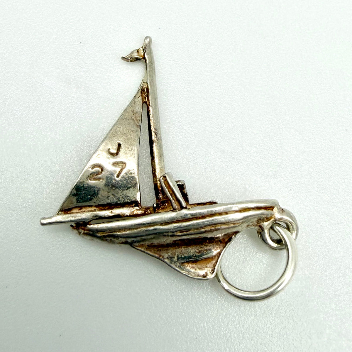 Vintage sterling silver J27 racing sailboat charm front view showing sail detail and jump ring