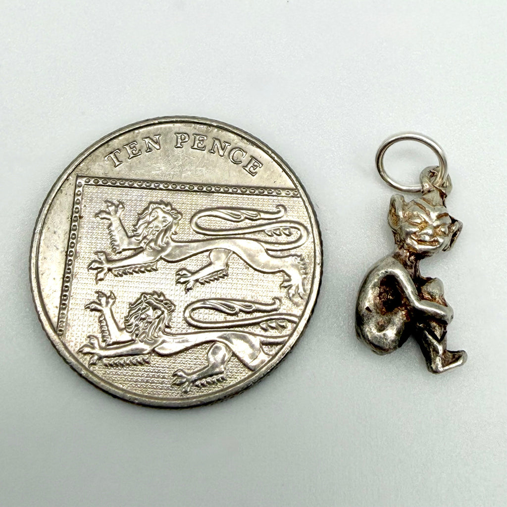 Seated imp pixie charm with handwritten weight and measurements