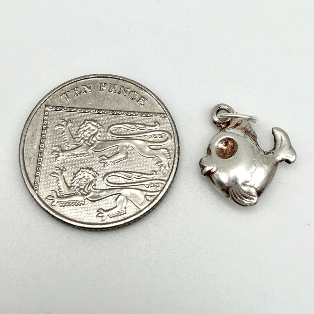 Vintage sterling silver fish charm seen from the other side showing engraved scales and the fish tail