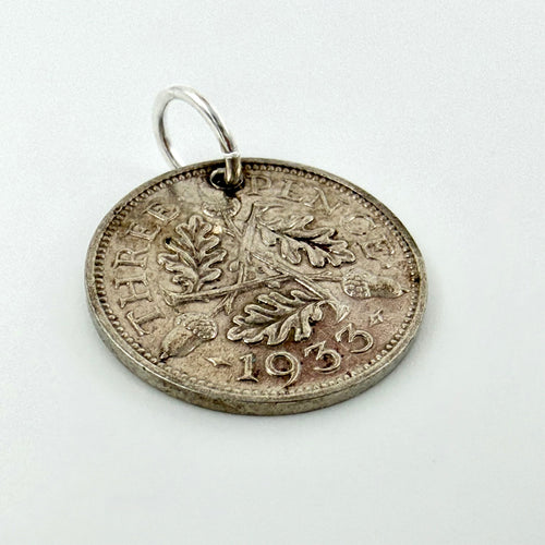 1933 silver threepence coin charm showing oak leaves and acorns beside a ten pence coin for scale