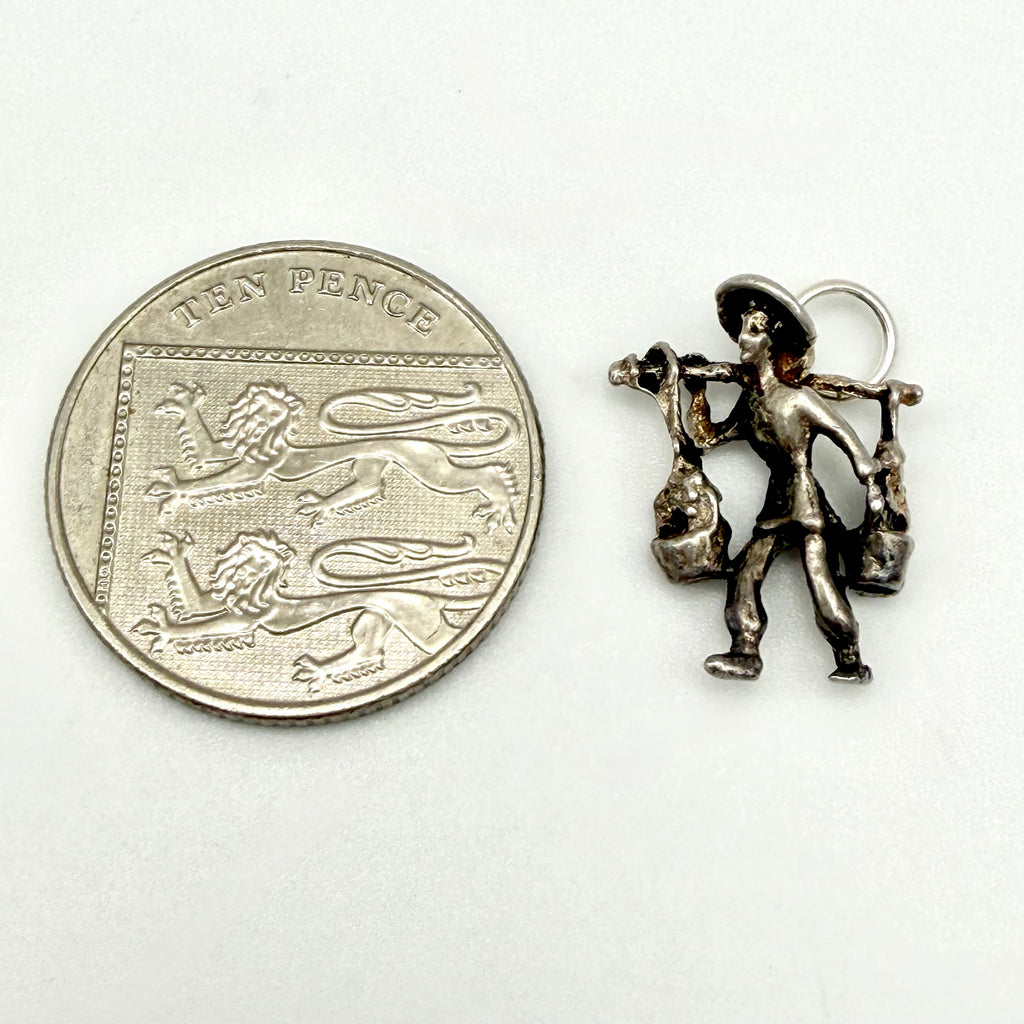 Close view of front of silver water carrier figure carrying two buckets
