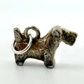Close view of vintage sterling silver terrier dog charm showing textured coat and hanging ring