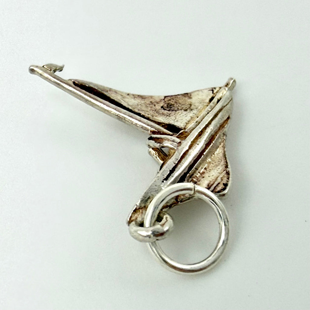 Close up of the sailboat charm showing J27 stamped on the sail