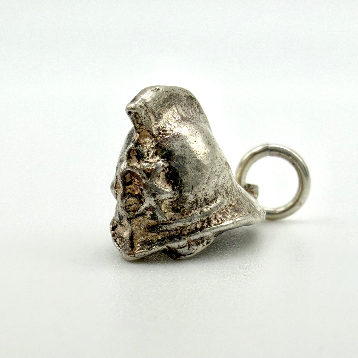 A small metallic Firmans helmet charm with a loop at the top, photographed on a plain light background.