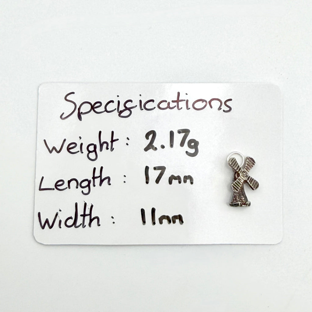 Front close view of vintage sterling silver windmill charm with four sails and darkened brick detail