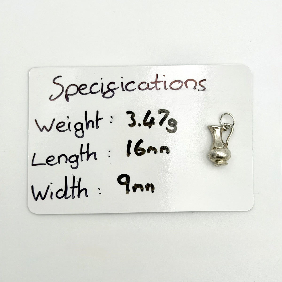 Reverse view of vintage sterling silver water jug charm