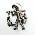 Water carrier charm beside a handwritten card showing its weight and measurements