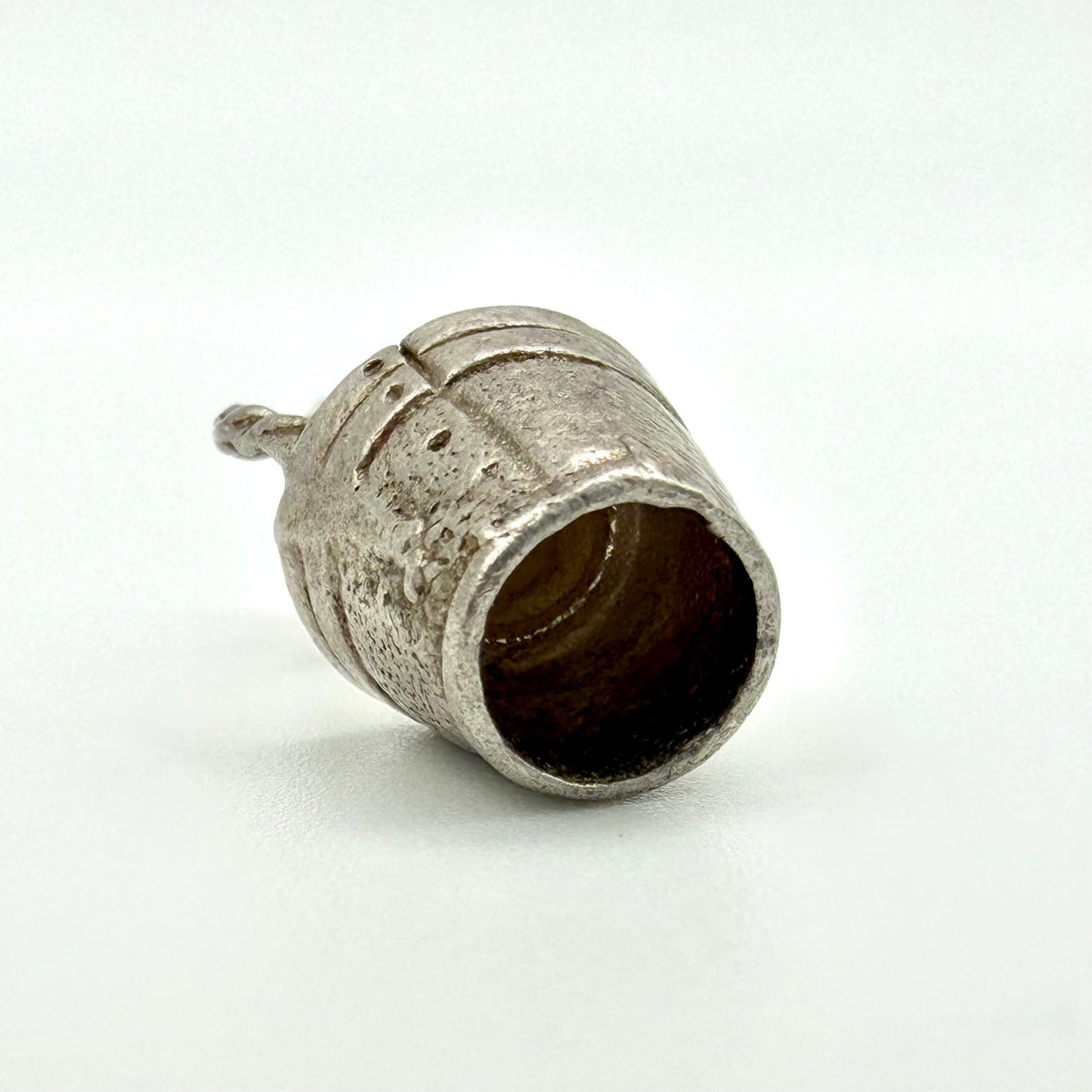 A small vintage-style silver bell-shaped ring with a textured, oxidized finish and a short stem, photographed on a clean white background.