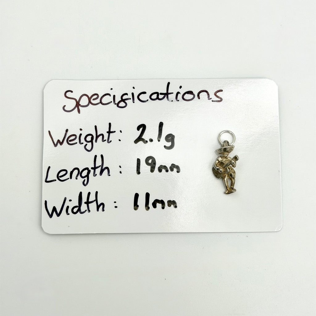 A small metallic charm or pendant displayed on a white card labeled 'Specifications' with handwritten measurements, weight, and dimensions.