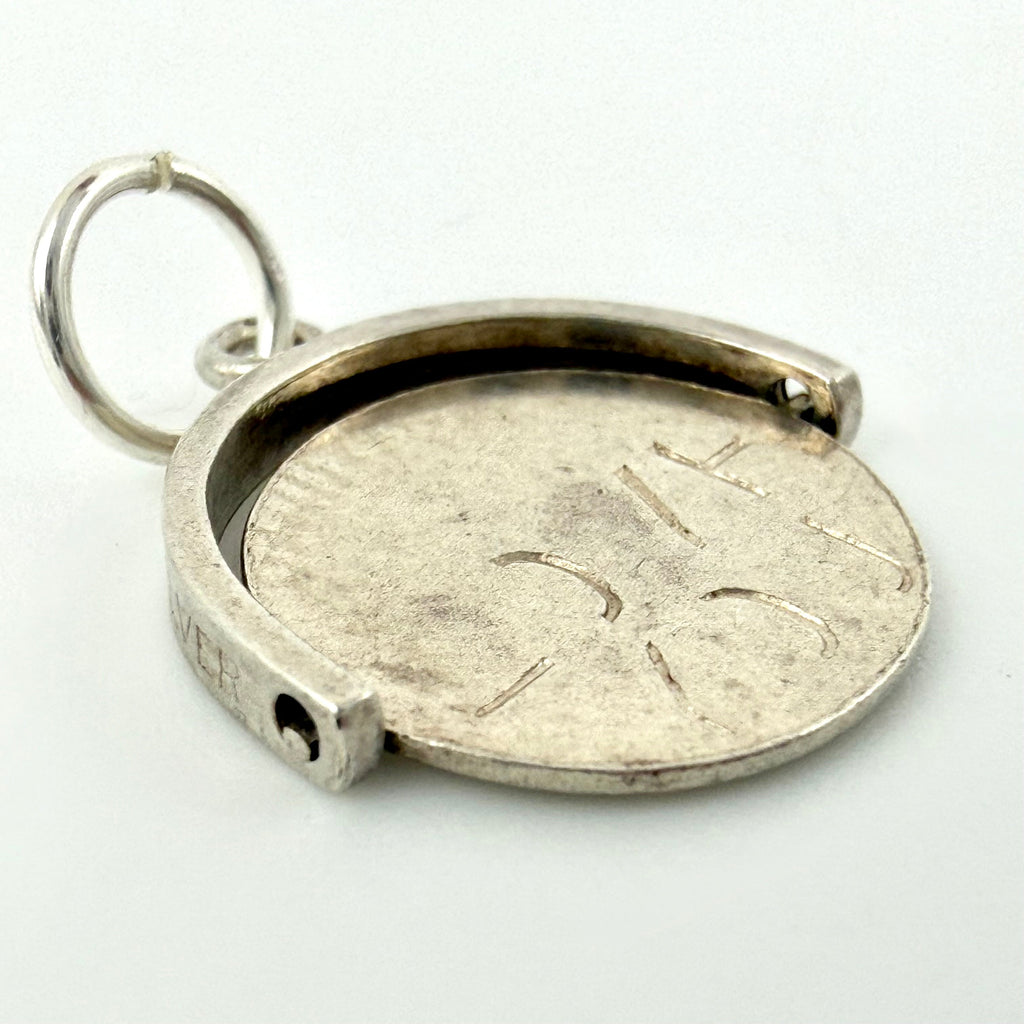 Angled view showing the charm’s spinning disc and outer frame
