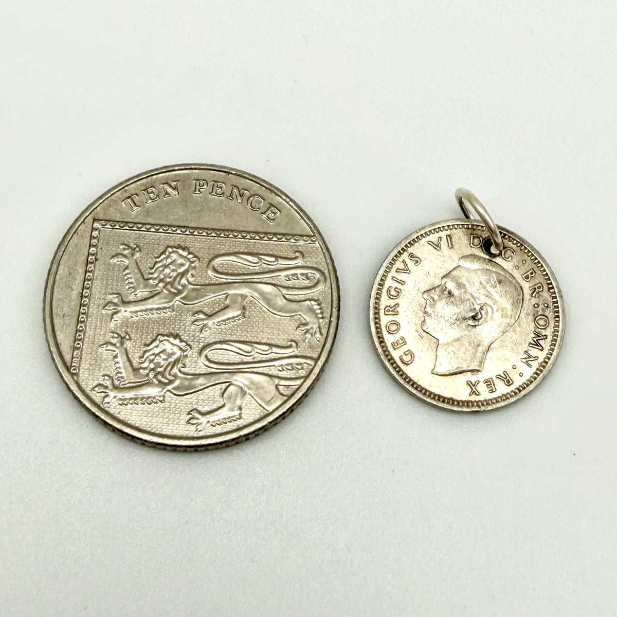 Close view of King George VI portrait on the threepence coin charm