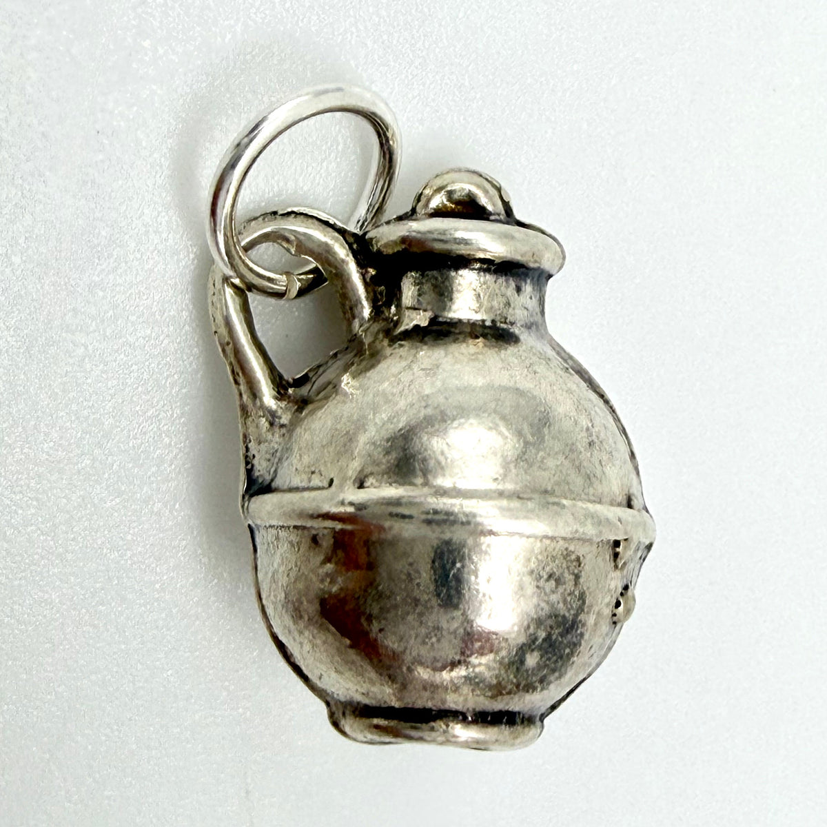 Side view of vintage sterling silver creamer jug charm showing handle and hanging ring