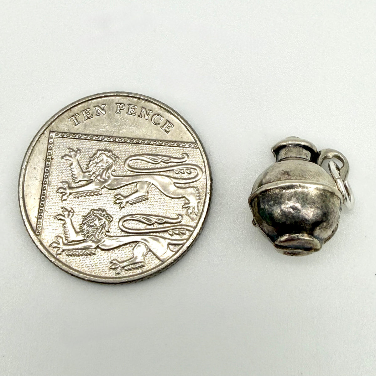 Vintage silver creamer jug charm beside handwritten measurements of 15mm by 13mm and 1g