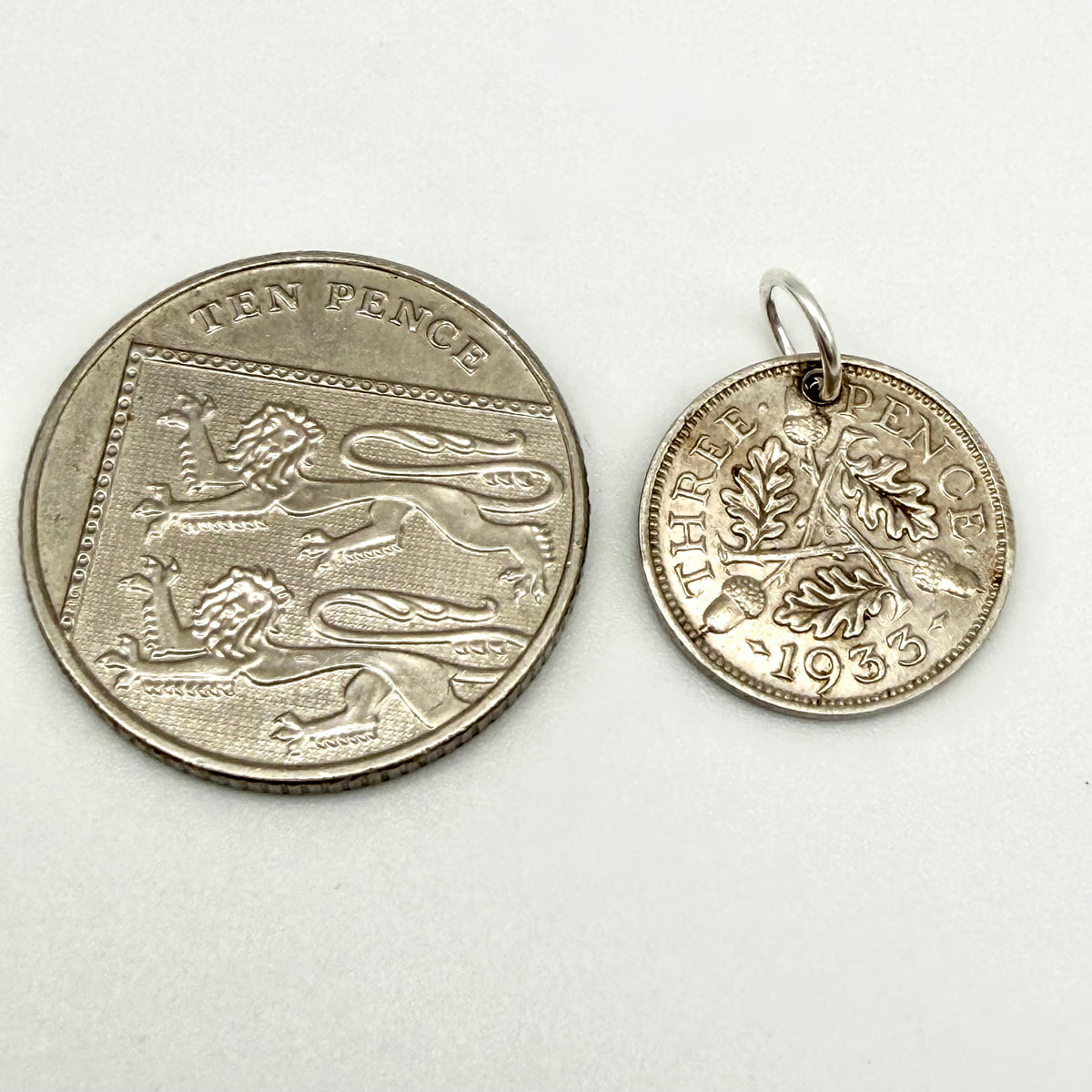 1933 threepence coin charm beside handwritten measurements of 16mm and 1.5g