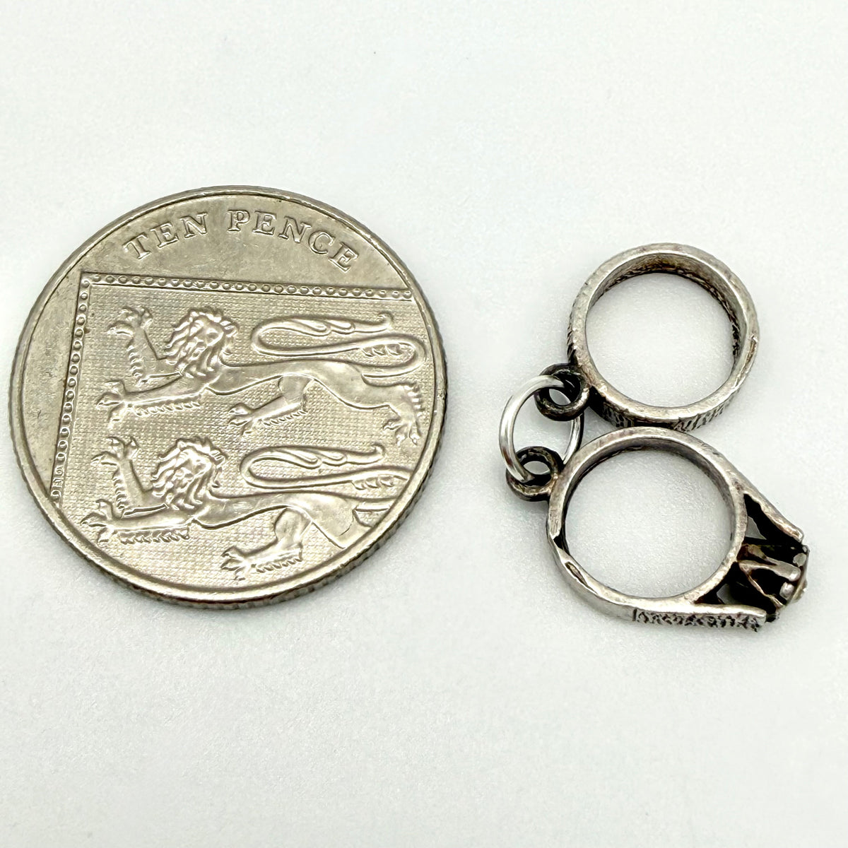Reverse view of the vintage sterling silver charm showing two linked rings and their connecting loop