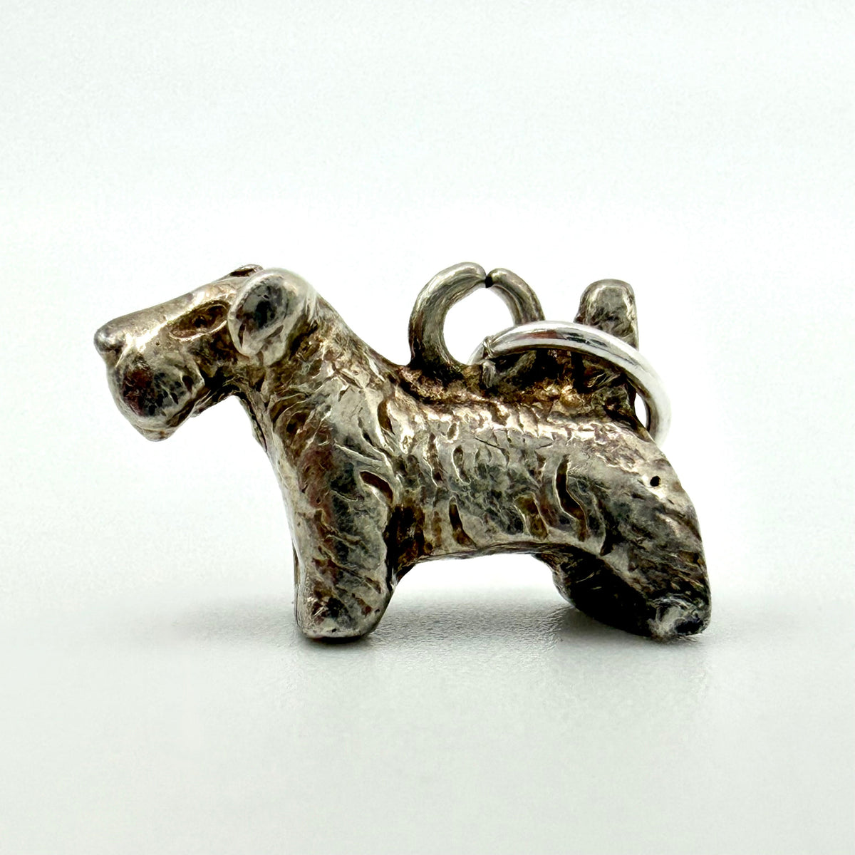 Terrier dog charm beside handwritten specifications showing 3.1g weight, 16mm length and 10mm width