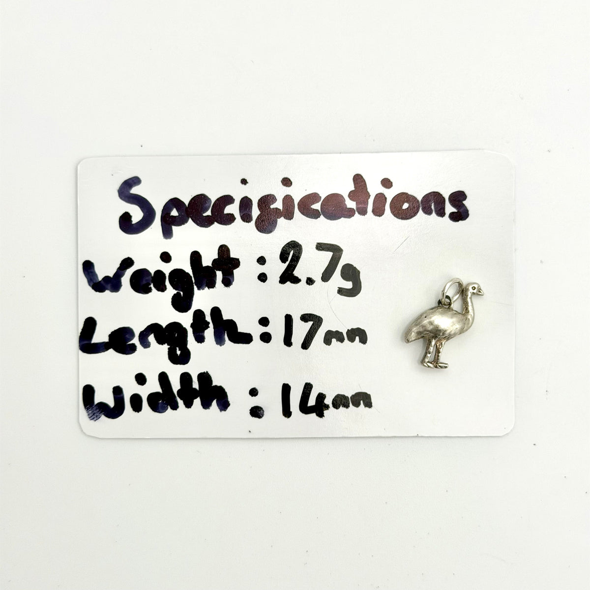 A small silver bird charm with a loop at the top, shown next to a white card labeled 'Specifications' with handwritten measurements and weight.