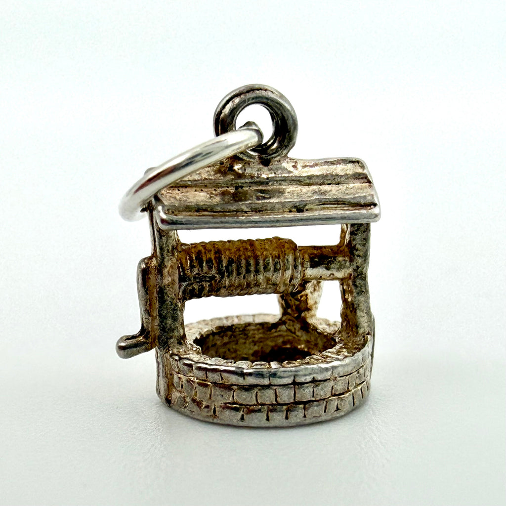 Wishing well charm beside handwritten measurements of 12mm by 10mm and 1.26g