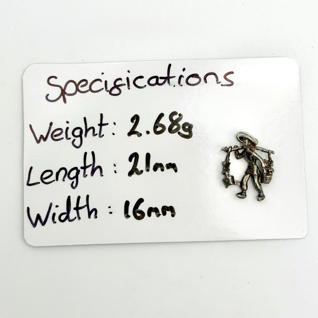 Front view of a vintage sterling silver water carrier charm with two vessels hanging from a shoulder pole