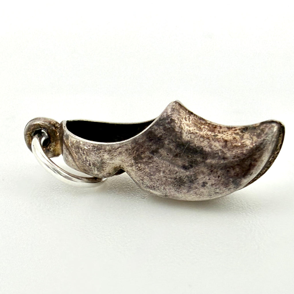 Side view of vintage sterling silver Dutch clog charm with an aged patina and attachment ring
