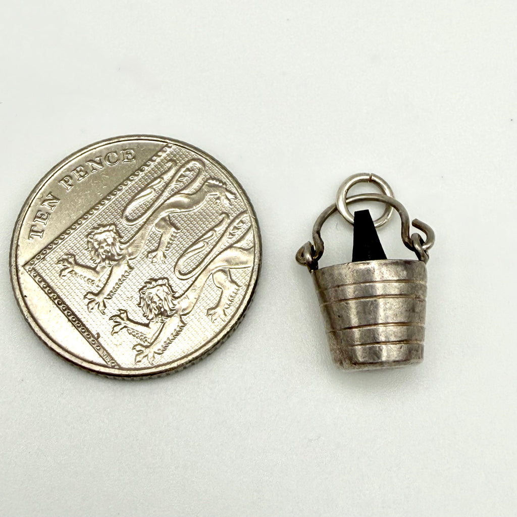 Vintage 925 sterling silver champagne bucket charm shown next to a ten pence coin for scale