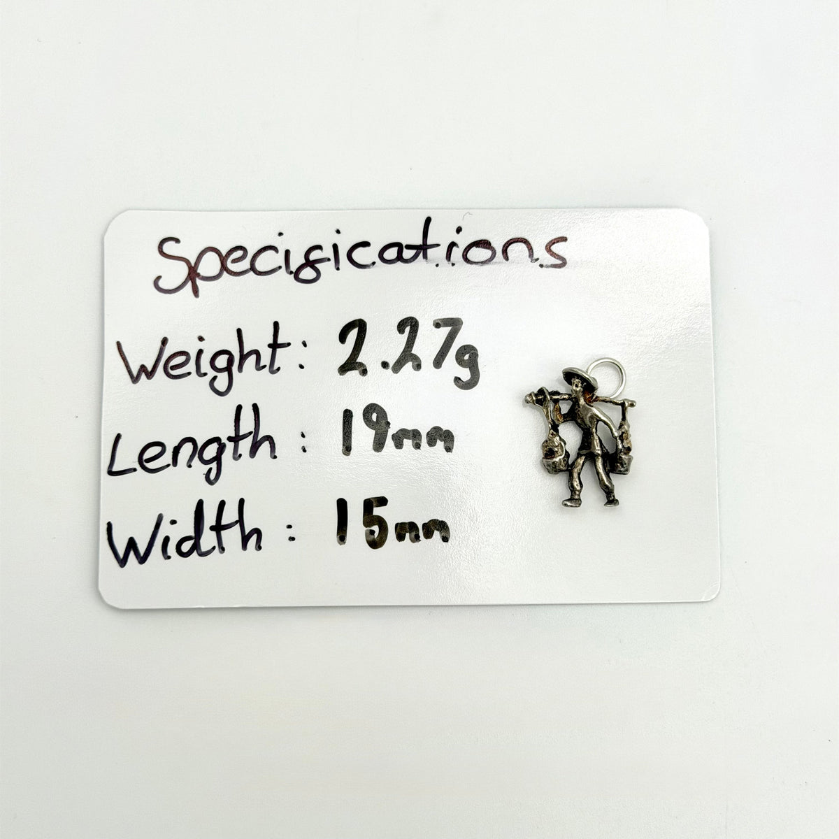 Angled reverse view of vintage silver water carrier charm and buckets