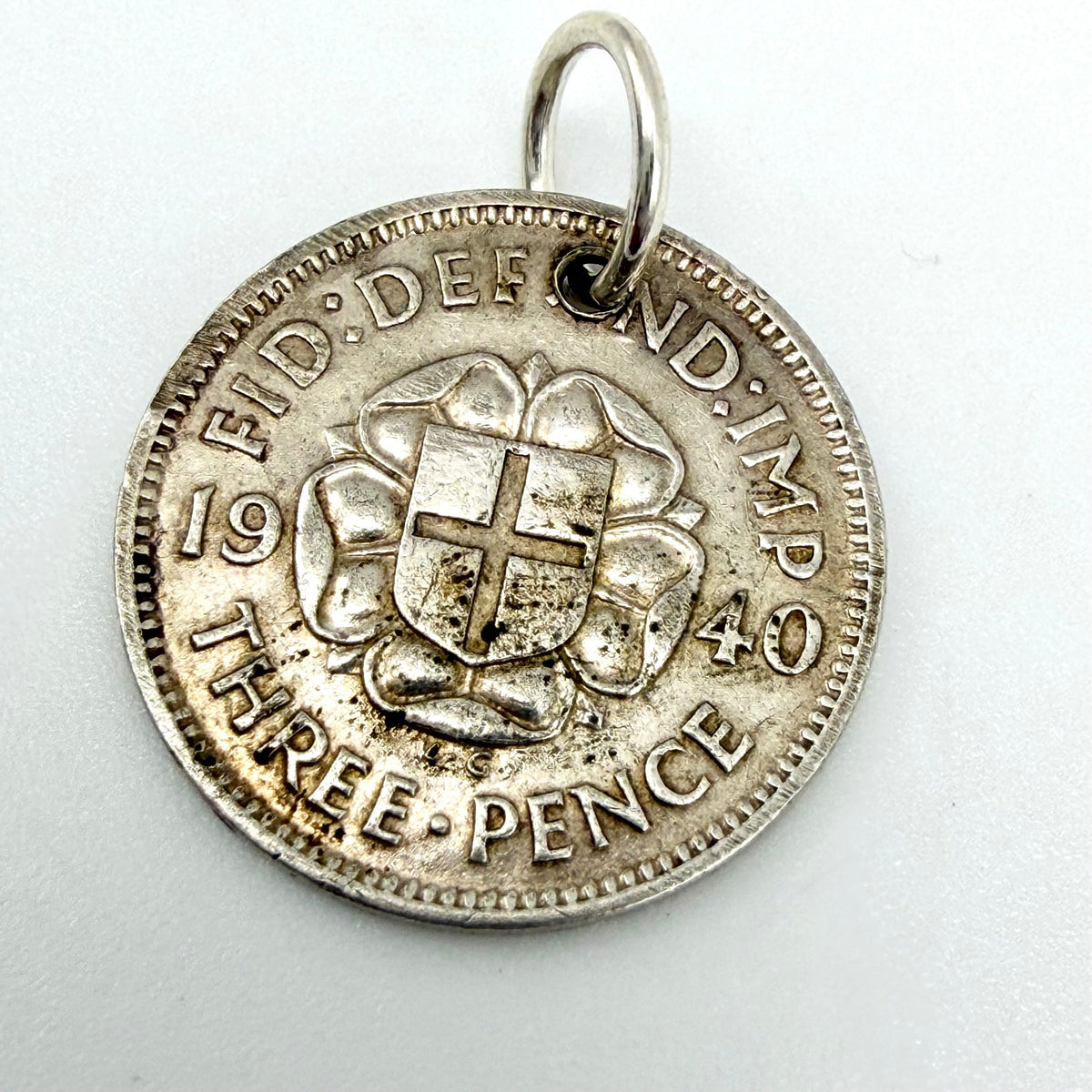 Angled view of the rose and shield side of the 1940 threepence coin charm